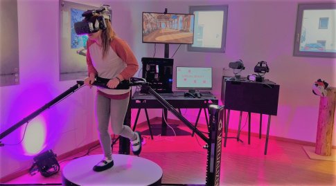 Anja läuft auf der beweglichen Sensor-Plattform des Virtualizers und schaut dabei durch eine VR-Brille. In der virtuellen Realität spaziert sie im selben Tempo durch den Spiegelsaal und schaut sich dort um.  